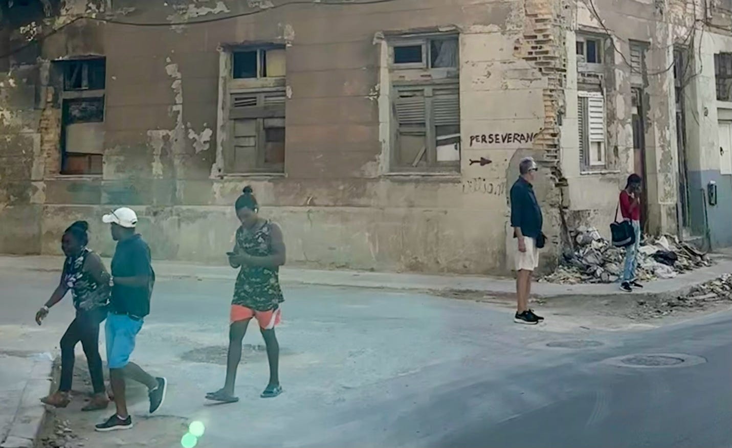 A group of people walking on a street

Description automatically generated