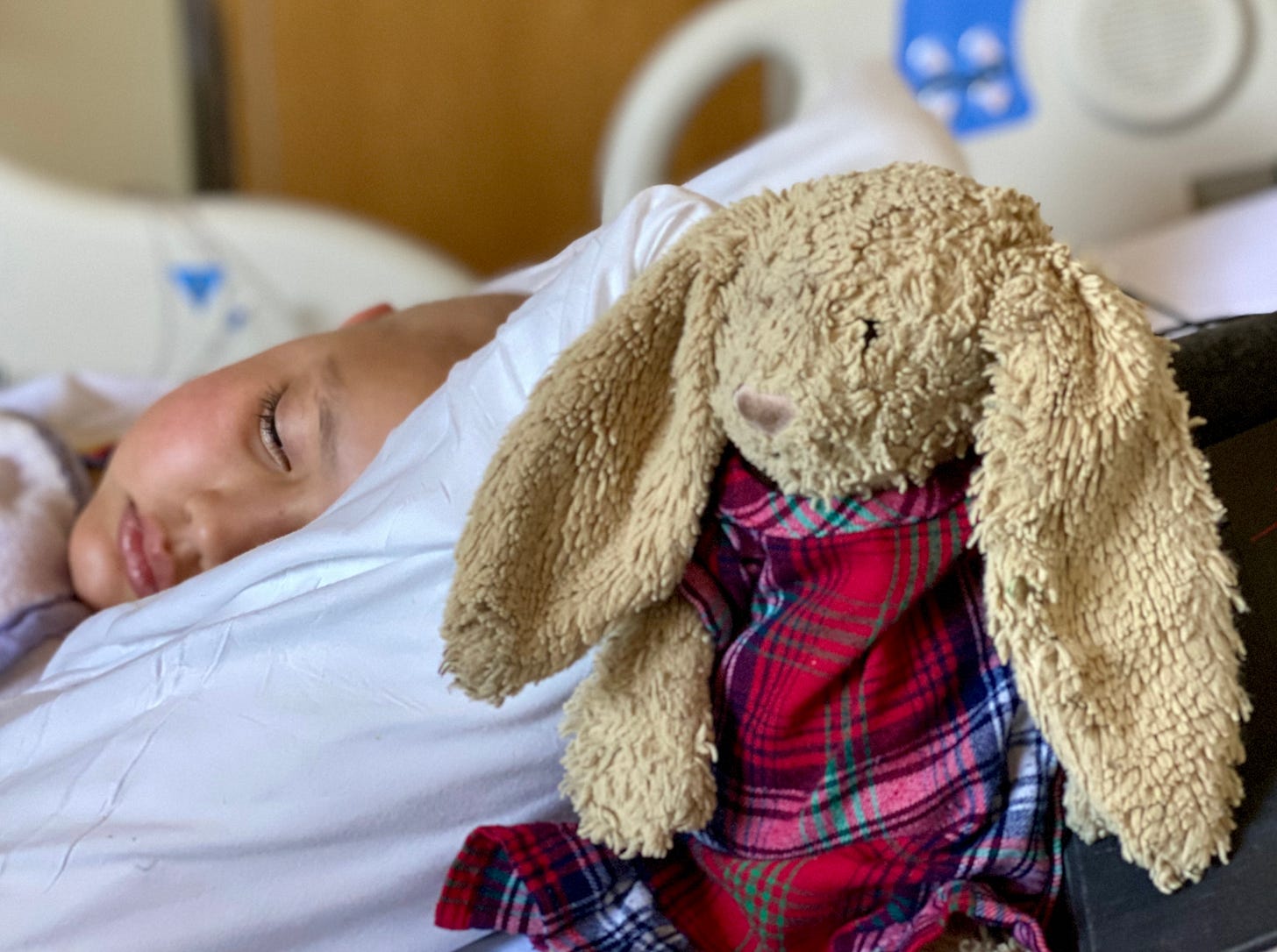 child in hospital bed and Snuffle Bunny stuffed animal