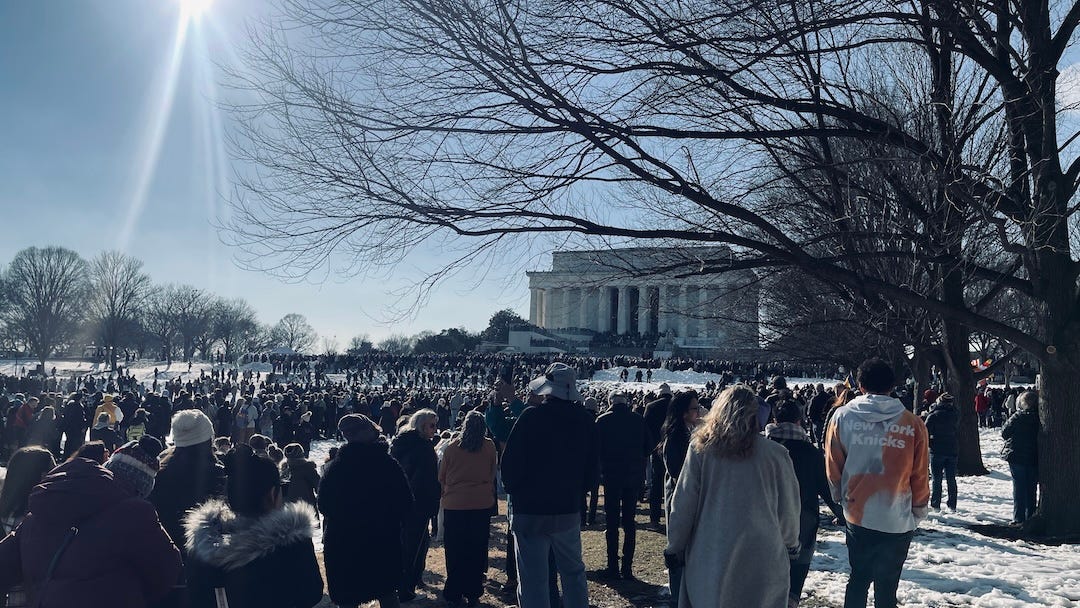 Crowds gathered in snow before the Lincoln Memorial under bright sunlight, witnessing the monks’ closing words at the conclusion of the Walk for Peace.