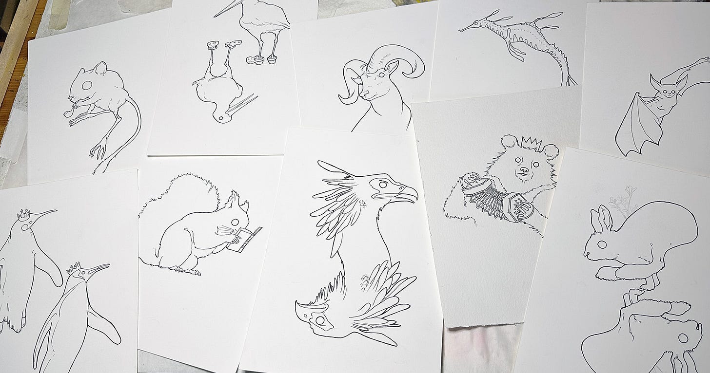 desk covered in pages of inked animal drawings