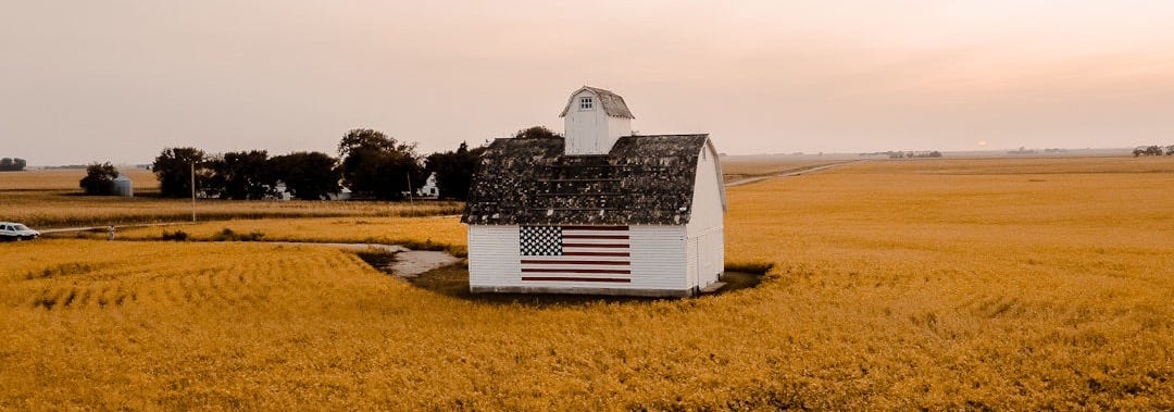 white and black house on brown field under white sky during daytime