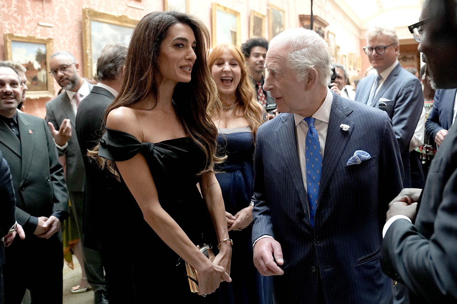 Amal Clooney in a black dress talking to King Charles