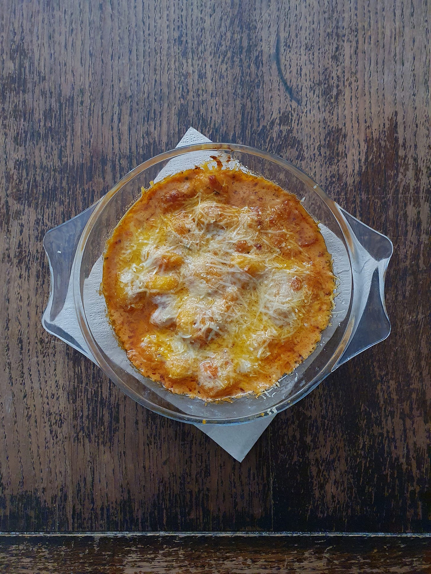 Photo of a dish of gnocchi in tomato sauce straight out of the overn