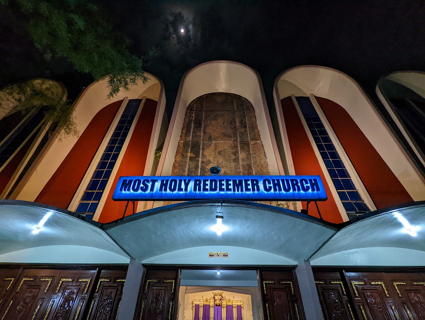 The main entrance of the Most Holy Redeemer Church as well as the moon in the night sky