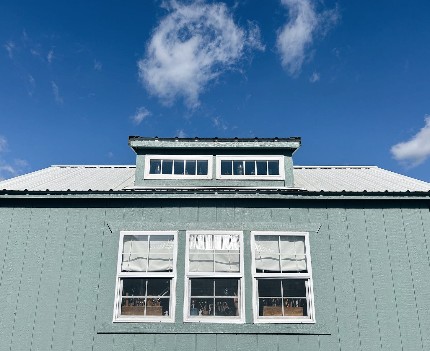 Blue skies and white clouds above my gray green studio