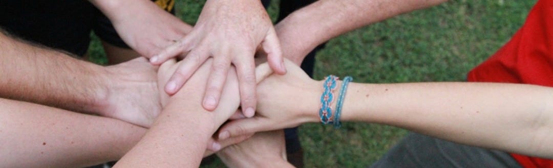 a group of people putting their hands together