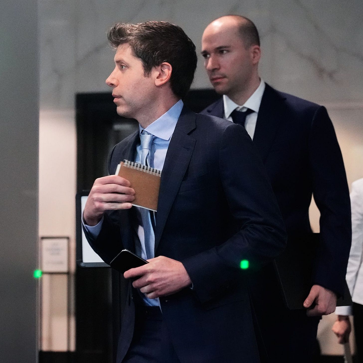 Sam Altman center and OpenAI president Greg Brockman right arrive at the U.S. District Court in Oakland Calif. Thursday...