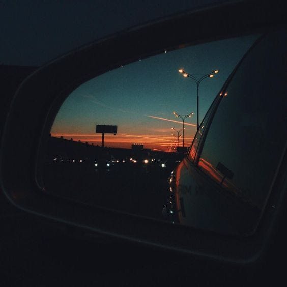 This may contain: the rear view mirror of a car at night with street lights in the background and an empty road sign This may contain: the rear view mirror of a car at night with street lights in the background and an empty road sign