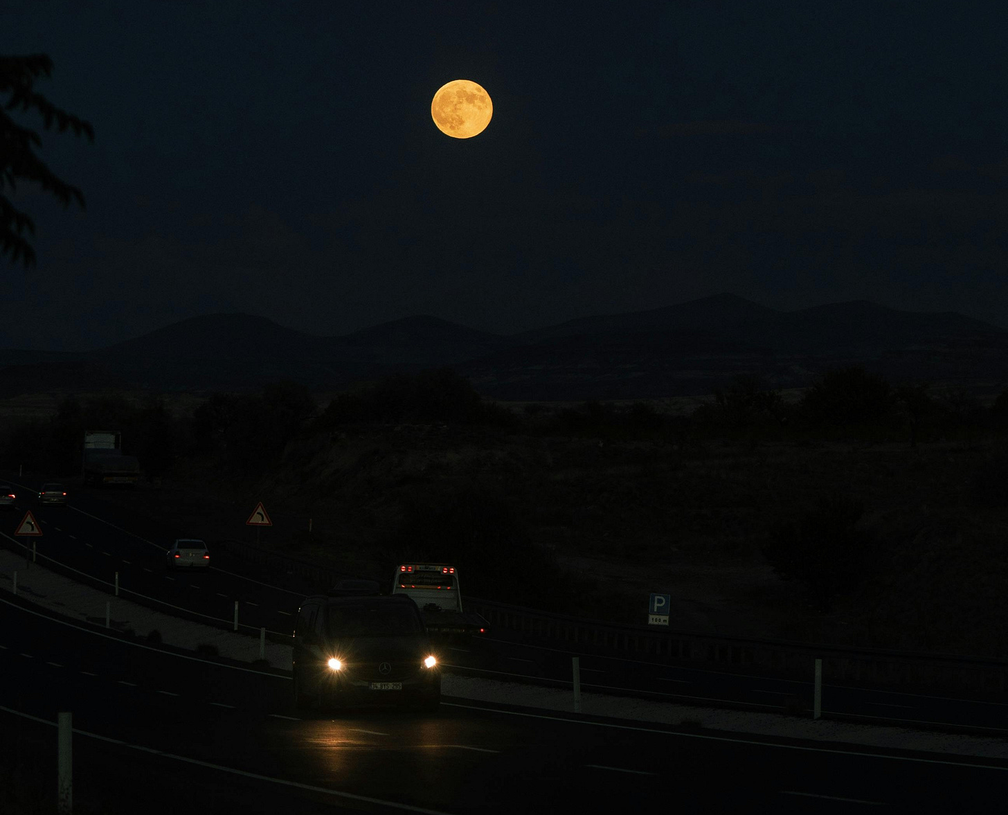 Full moon over a highway at night Full moon over a highway at night