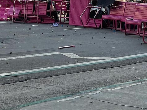 The first photo shows police on horses and one of them swinging his batton to hit a person dressed in all black. The second photo shows police shooting white chemical agent into crowd, the third photo shows pink tables and chairs that are being used as a barricade.