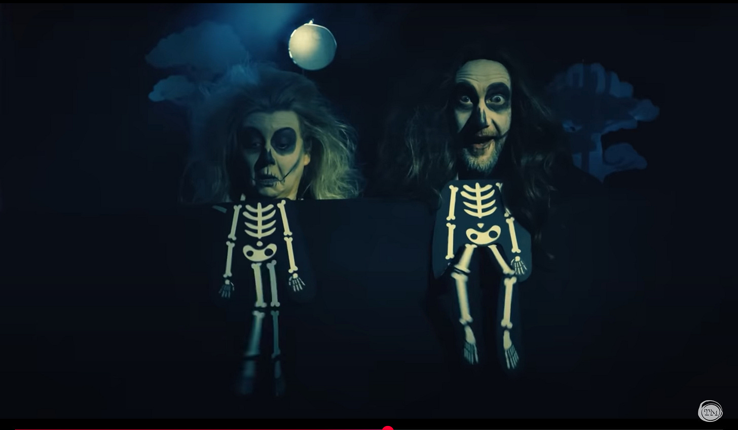 Rosie Ramsey and Little Alex Horne wear skeleton face paint, with dancing skeletons below their heads.
