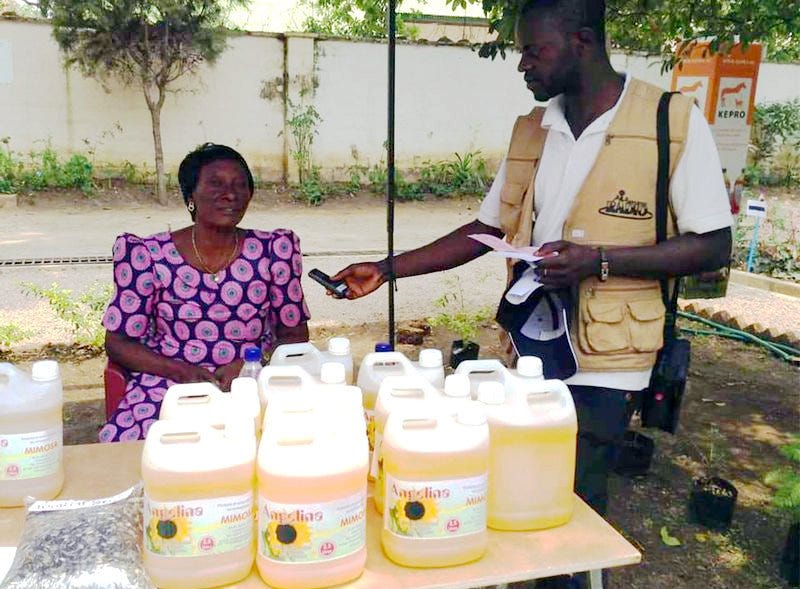 Ange Kanonga during an interview with some bottled sunflower oil displayed on the table.