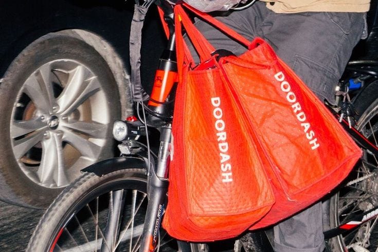 This may contain: a person riding a bike with an orange bag on it's handlebars