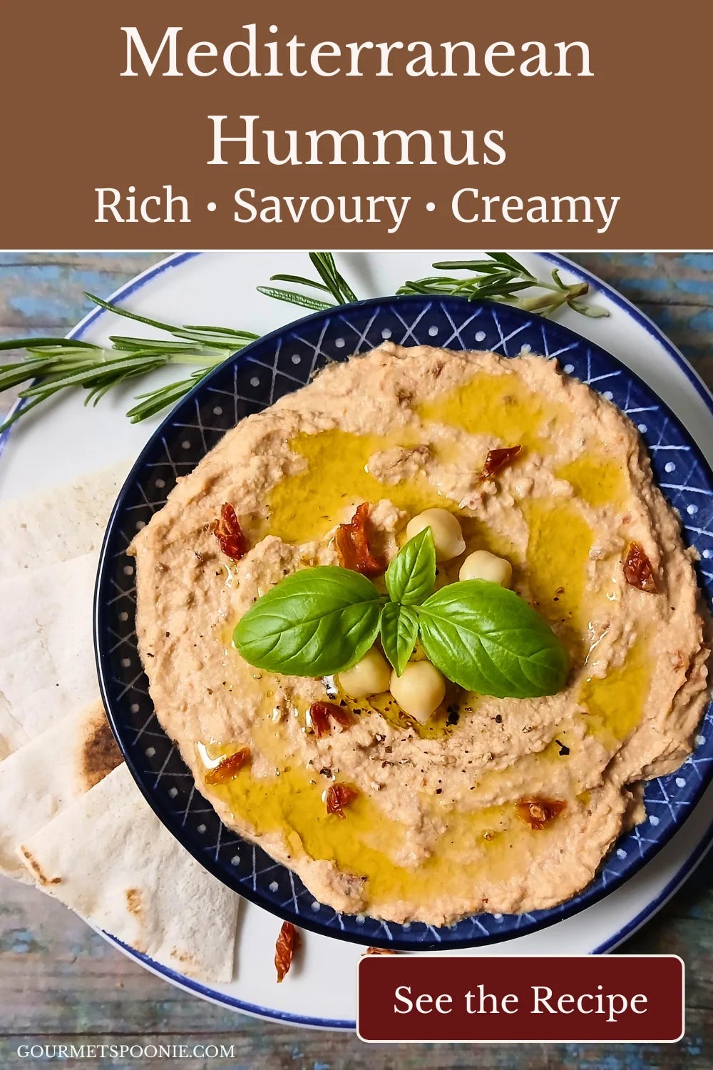 Creamy homemade sun-dried tomato hummus garnished with basil and olive oil in a blue bowl. Creamy homemade sun-dried tomato hummus garnished with basil and olive oil in a blue bowl.