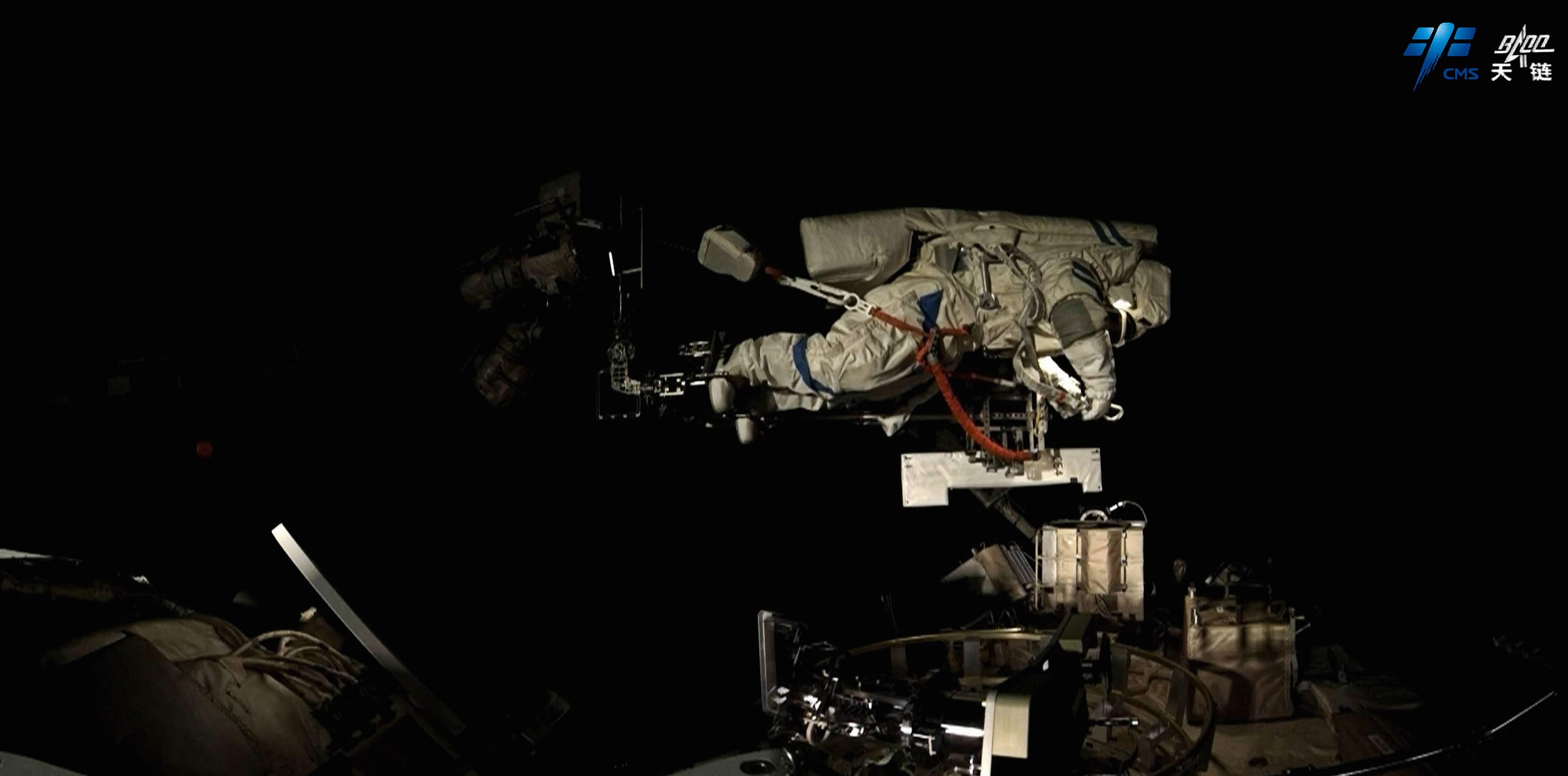 Chen Dong is on Tiangong’s robotic arm, carrying hardware for installation on the outside of the space station. Chen Dong is on Tiangong’s robotic arm, carrying hardware for installation on the outside of the space station.