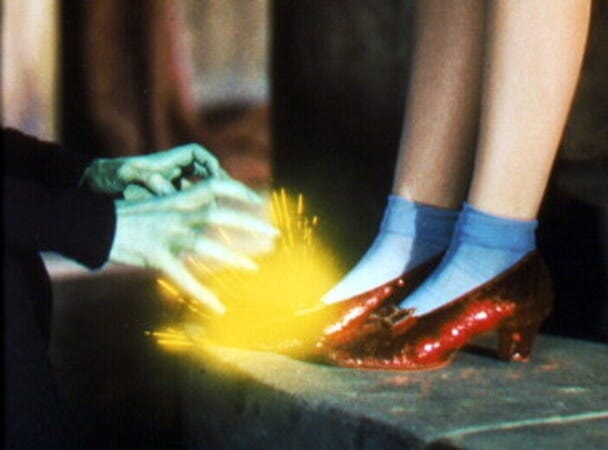 Sparks fly off Dorothy's ruby slippers as the Wicked Witch of the West reaches for them