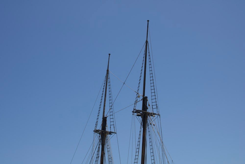 black sail boat on blue sky