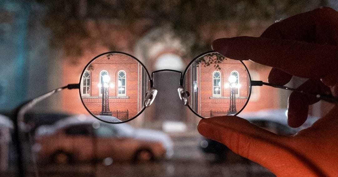 person holding black framed eyeglasses