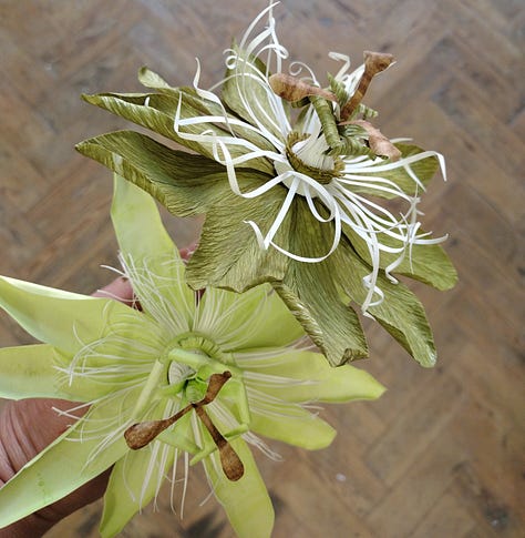 A selection of paper flowers including passion flowers, bindweed, foliage and dahlias
