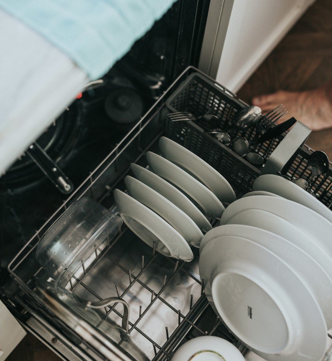 white ceramic plate on black dishwasher