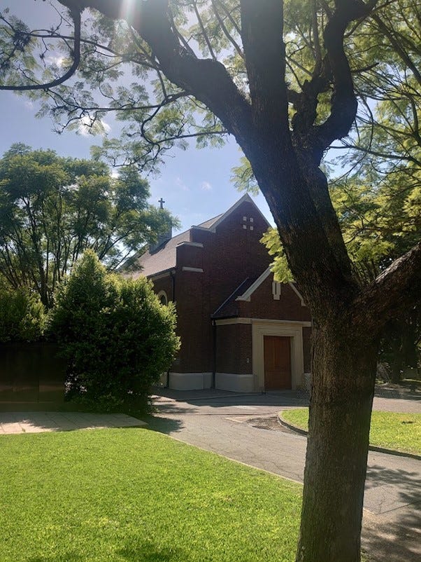 Chapel in a Cemetery surrounded by trees and greenery. A graveyard with a water tower covered in Ivy.