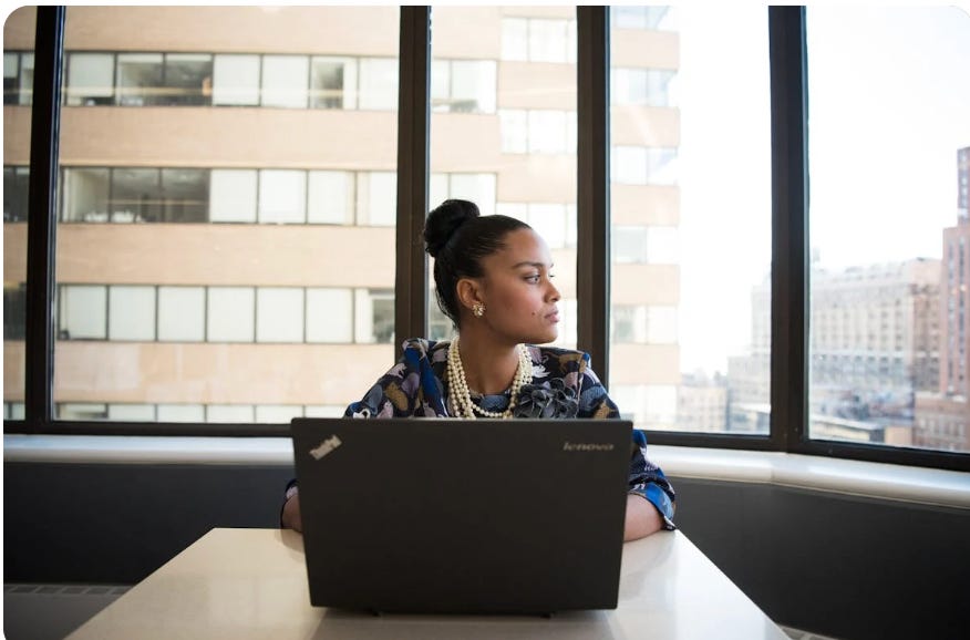 a person looking out the window alone in an office