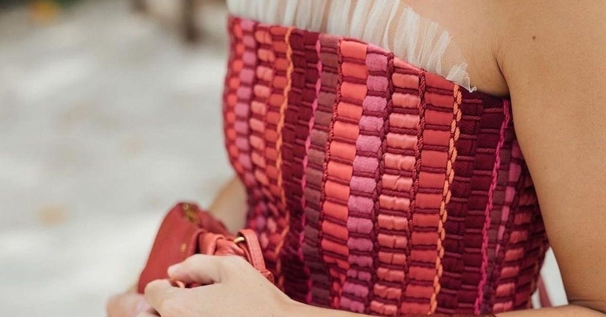 Detalle del look de invitada de boda. Cuerpo con textura en tonos rosas, naranjas y burdeos empolvados Detalle del look de invitada de boda. Cuerpo con textura en tonos rosas, naranjas y burdeos empolvados