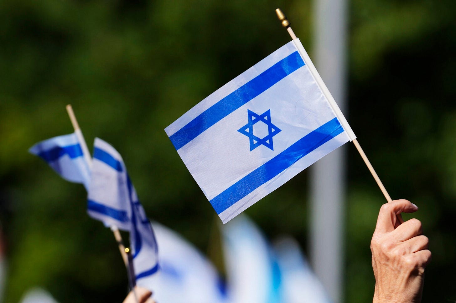 Supporters of Israel hold Israel flags at a Jewish United Fund-hosted solidarity event in Glencoe, Ill. Supporters of Israel hold Israel flags at a Jewish United Fund-hosted solidarity event in Glencoe, Ill.