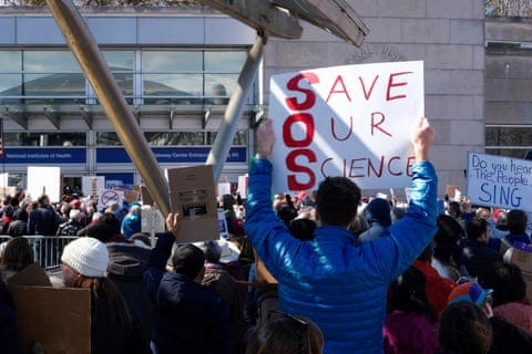 a person holds a sign that reads 'save our science' a person holds a sign that reads 'save our science'