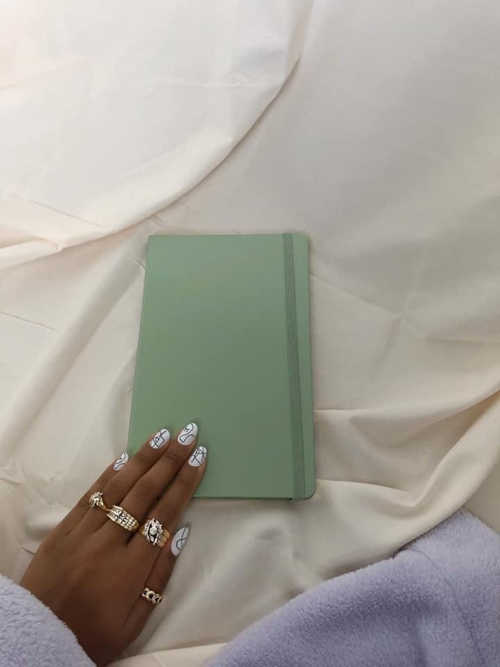 Kelsey-Marie's hand on her moleskin journal