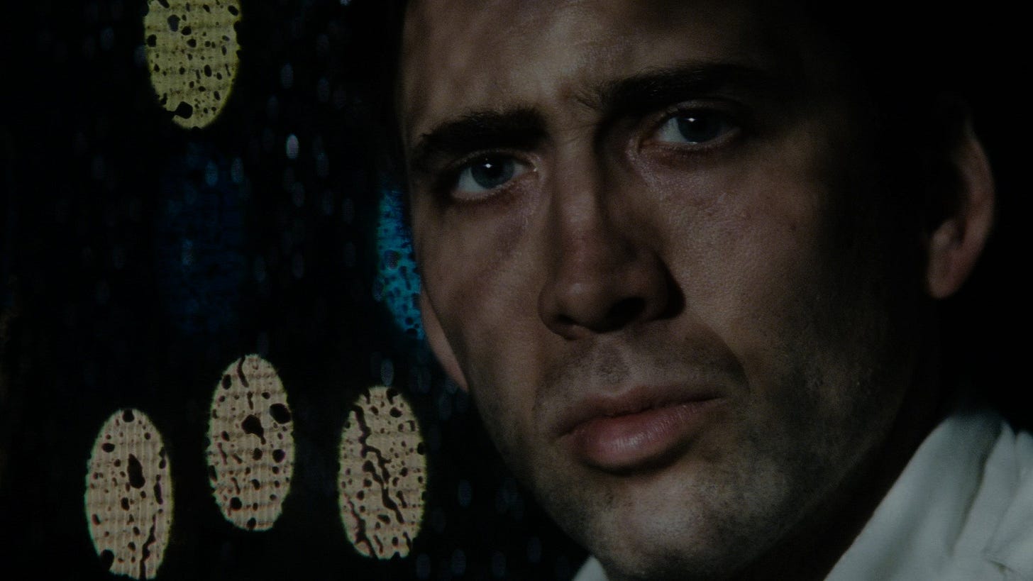 Bringing Out the Dead | Still features Nicolas Cage staring directly into the camera, tired and weary – against a rainy window.