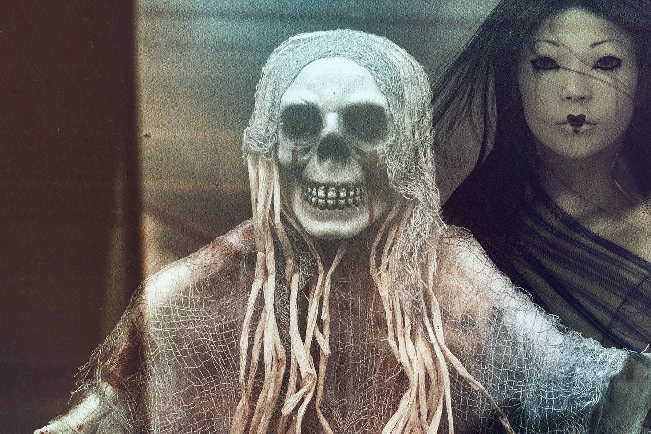 A colour composite photo and AI image by Karen Nadine from Pixabay of a skeleton looking forward and wearing a netlike headpiece and shawl, standing in front and to one side of a young, eerie looking geisha-like woman.