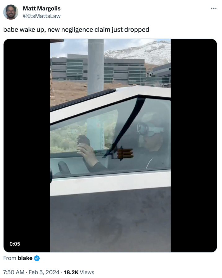 Photo of a person wearing Apple Vision Pro goggles in a CyberTruck with hands off the wheel.  Caption: babe wake up, new negligence claim just dropped