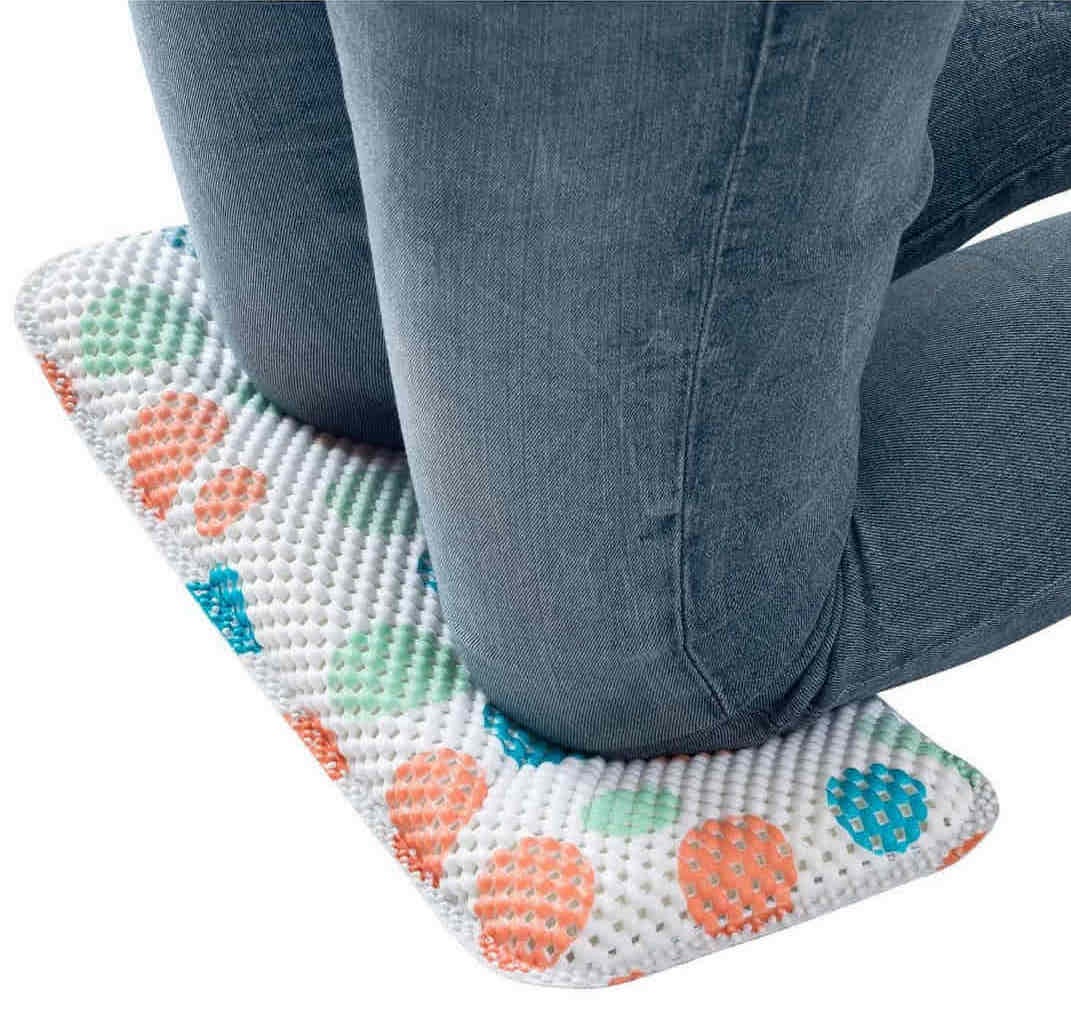 A pair of knees kneeling on a foam mat