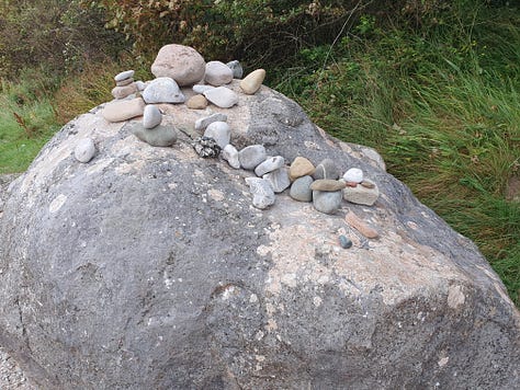 9 pictures of one large rock, each picture has different configurations of small rocks piled on top of it