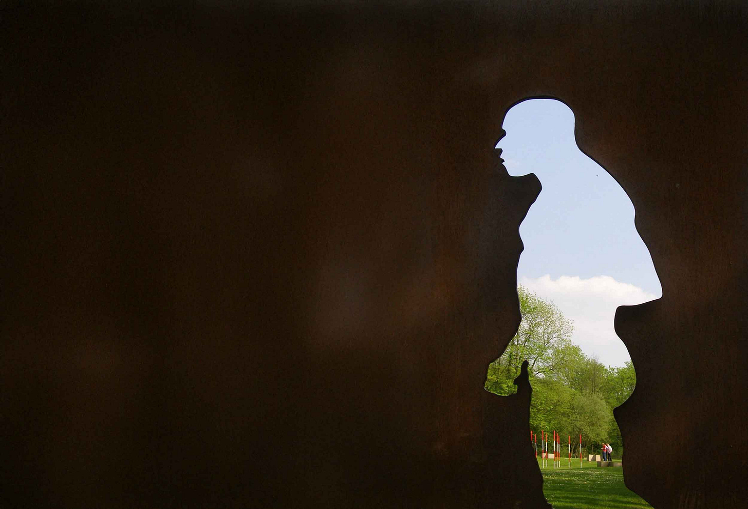Silhouette cutout of Neandertal with trees and landscape visible through the cutout