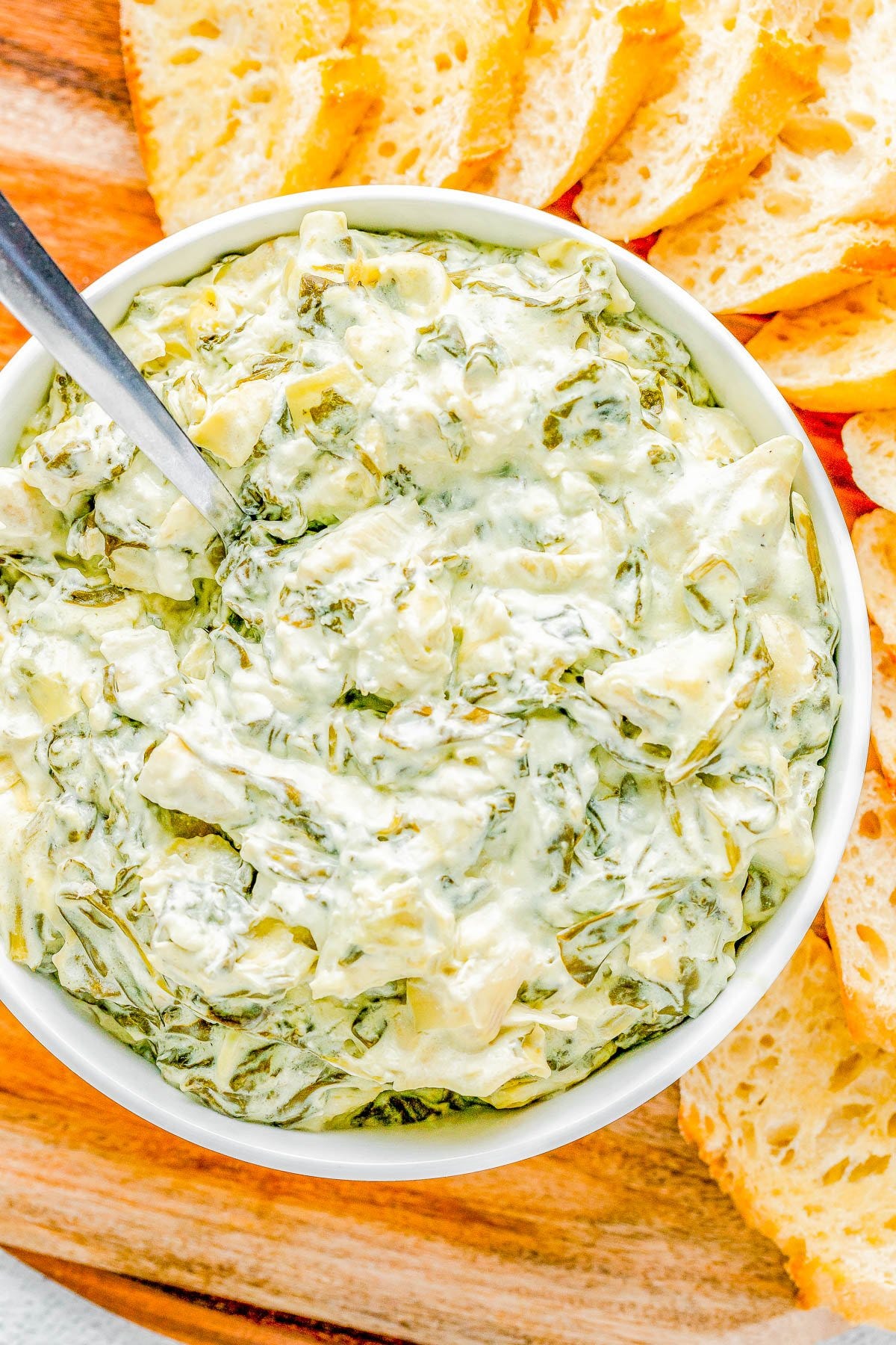 A bowl of crockpot spinach artichoke dip. 