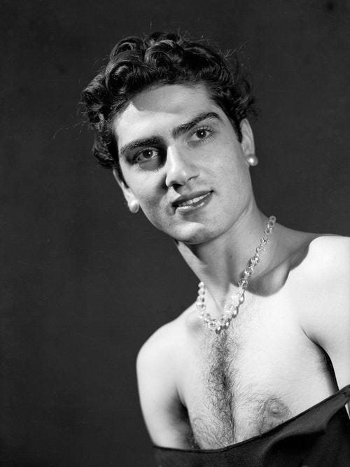 Photo of Van Leo waring a necklace and top that shows his chest