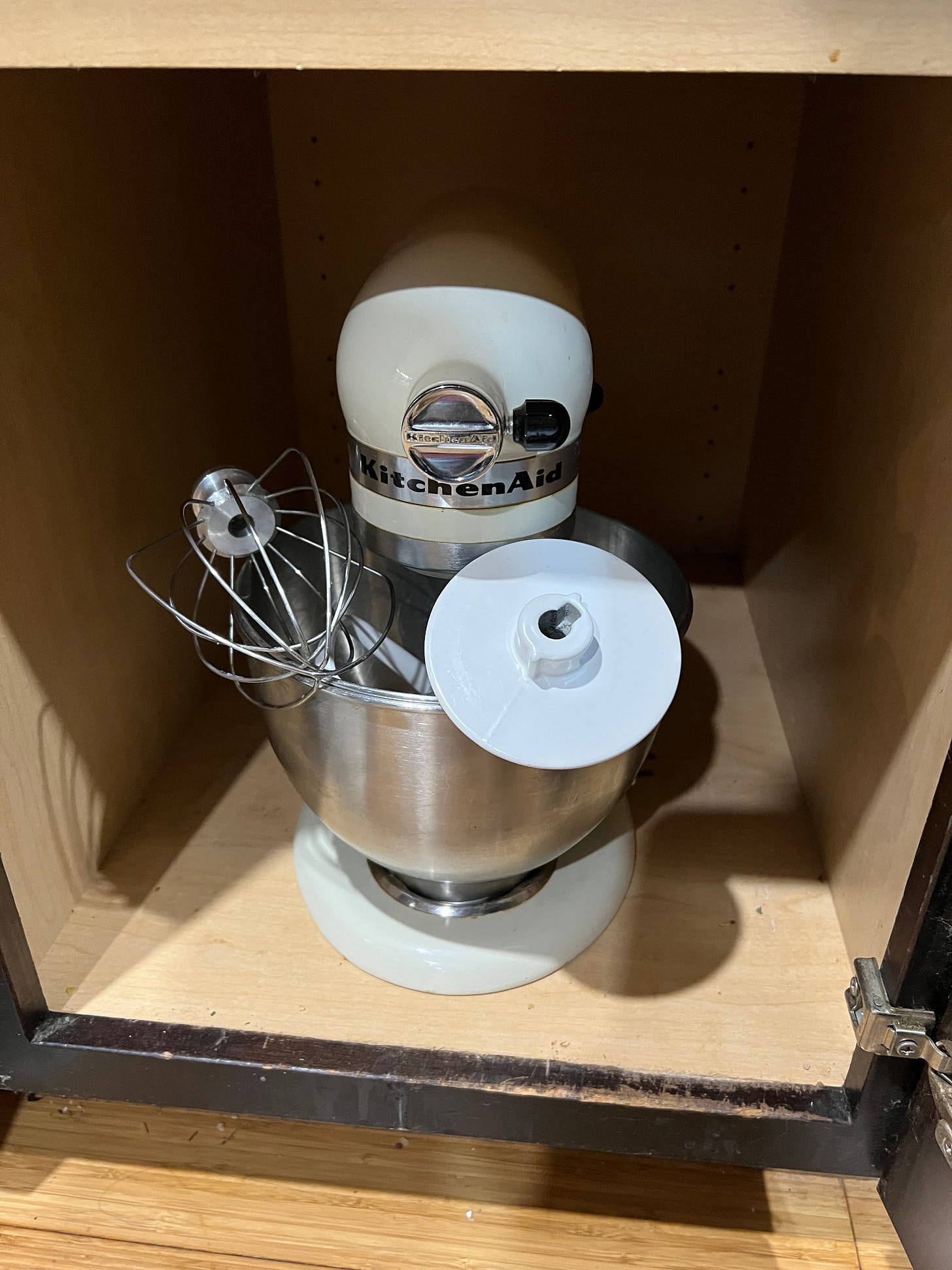 a standing mixer inside a cabinet