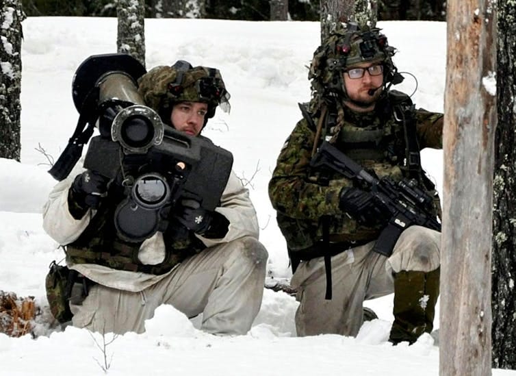 Two soldiers on a winter Nato exercise in the snow. Two soldiers on a winter Nato exercise in the snow.