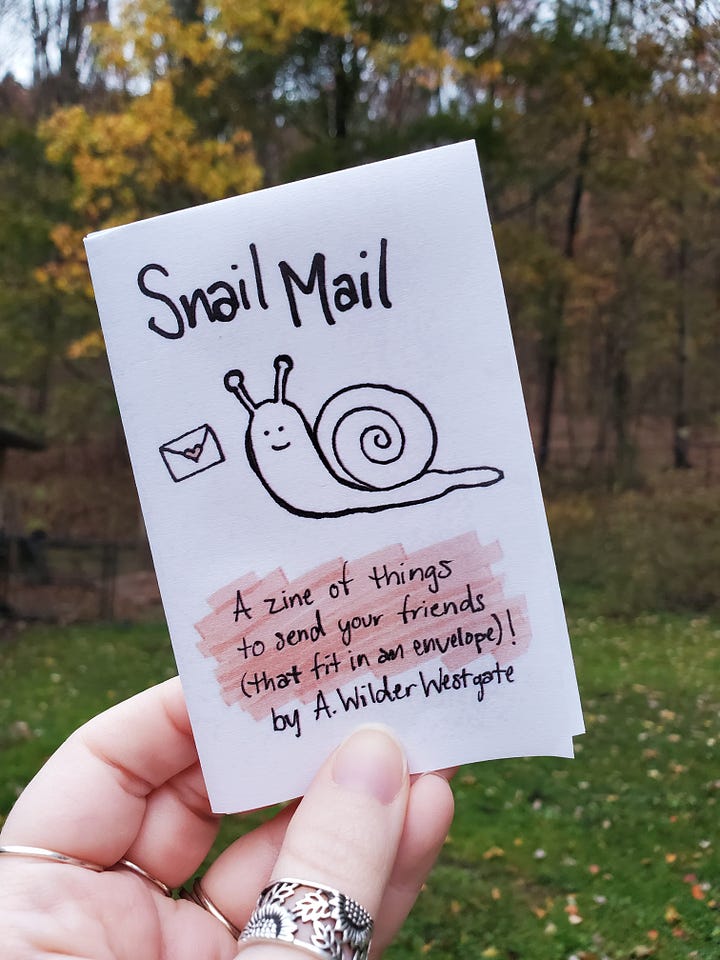 First photo: the cover of a one page mini zine, featuring a snail and tiny envelope. Second photo: a view of the zine unfolded. 