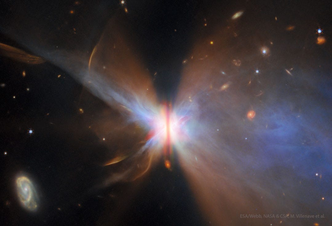 A starfield surrounds a nebula with a vertical brown bar
across its center. Gas and dust fan out from the bar
making the nebula appear like a colorful butterfly. 
Please see the explanation for more detailed information.