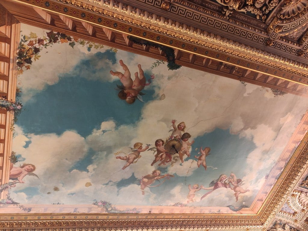 Naked nymphs or angels painted in bright colours on a background of cloud and blue sky - the ceiling in the library