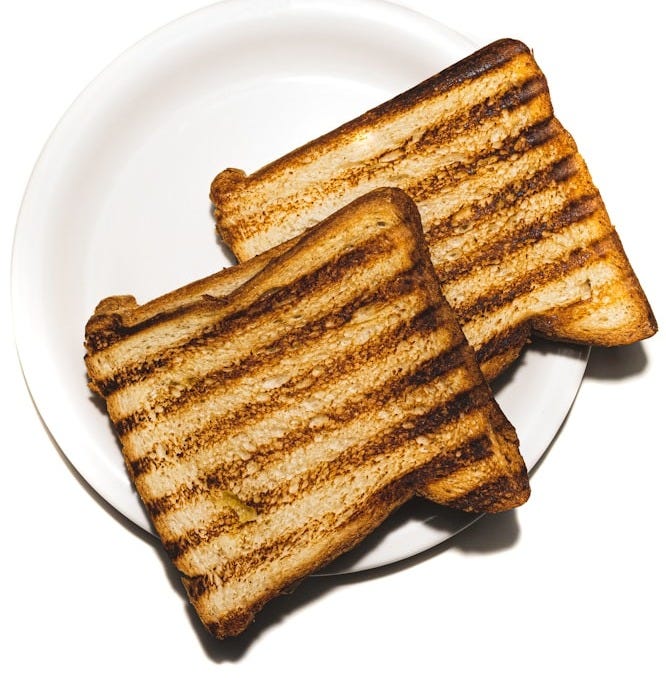 brown and black bread on white ceramic plate brown and black bread on white ceramic plate