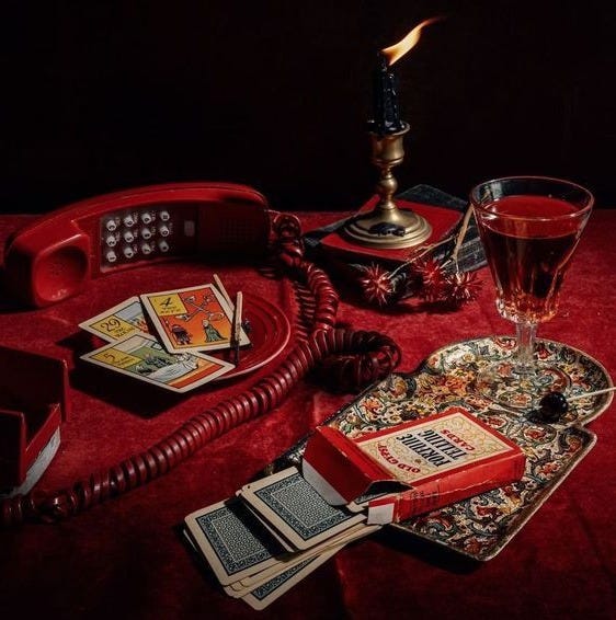 This may contain: a red phone sitting on top of a table next to a glass filled with liquid This may contain: a red phone sitting on top of a table next to a glass filled with liquid