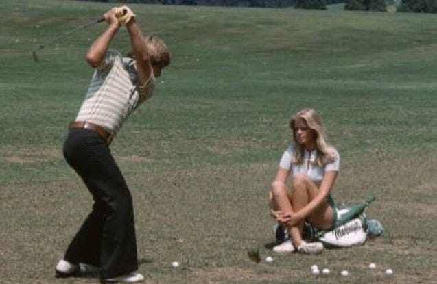 This may contain: two people are playing golf in the field This may contain: two people are playing golf in the field