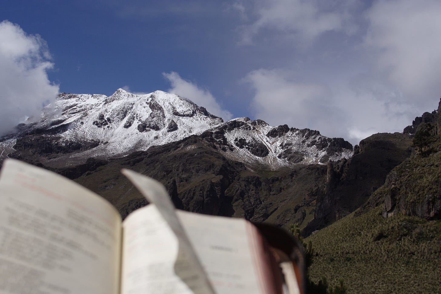 Book page in breeze against mountain scene