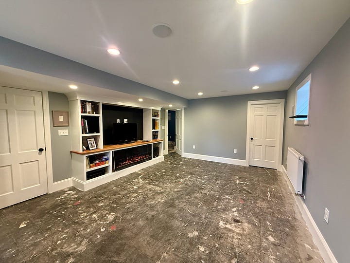Two photos showing the "after" of a family room and office as part of a basement renovation with lights, paint, artwork, etc.