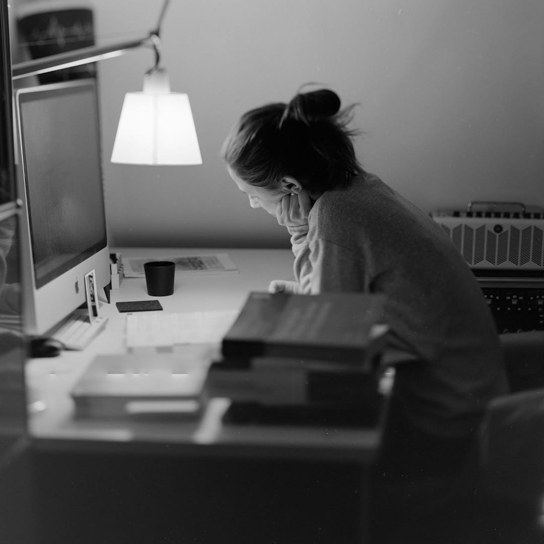 a woman sitting at a desk with a computer a woman sitting at a desk with a computer