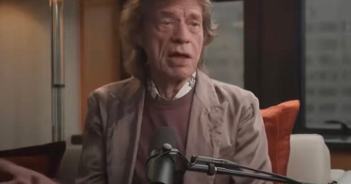 Mick Jagger discussing music and life in a cozy interview setting with a microphone and modern decor. Mick Jagger discussing music and life in a cozy interview setting with a microphone and modern decor.